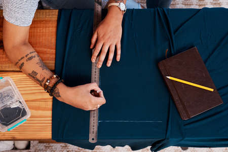 This is how much Ill need. an unrecognizable woman making a garment at home.