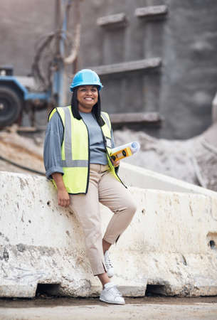 Everythings under control on my site. Full length portrait of an attractive young female construction worker working on site.の写真素材