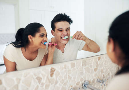I cant wait for my kiss. a young couple brushing their teeth together.の写真素材