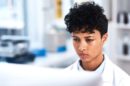 Her focus never falters. a young scientist working on a computer in a lab.の写真素材