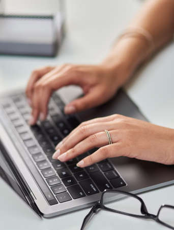 Putting her fingers to work. High angle shot of an unrecognizable businesswoman working on a laptop...