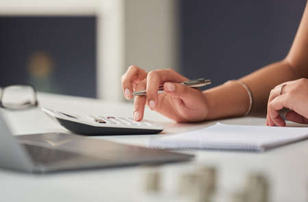 You can never be too prepared. an unrecognizable businesswoman working out her finances with a...