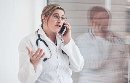 I expected that youd call me first. an attractive young female doctor speaking expressively on her...