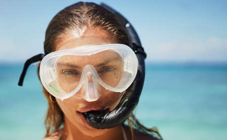 Theres beauty beneath the surface. Cropped portrait of an attractive young woman in scuba gear on the beach.の写真素材