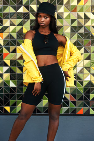 Its all about confidence and how you feel about yourself. Cropped portrait of an attractive young woman standing alone against a brightly tiled wall during the day.の写真素材