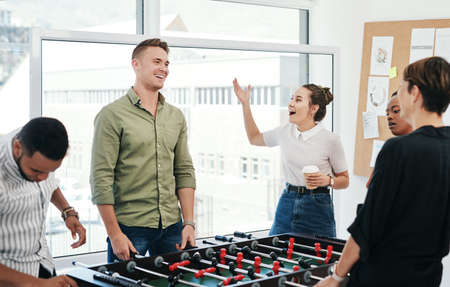 How did you lose that. a diverse group of businesspeople standing together and bonding over a game...