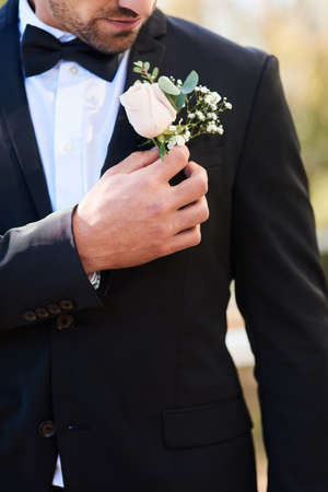 Flowers fit perfectly in any occasion of celebration. an unrecognizable young bridegroom adjusting...