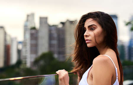 Shes simply mesmerising. an attractive young woman standing on a balcony outdoors during the day.の写真素材