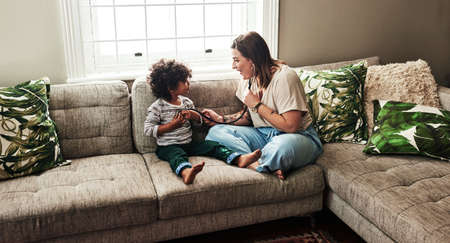 I can hear your heartbeat. a cheerful young woman and her son playing around with a stethoscope...