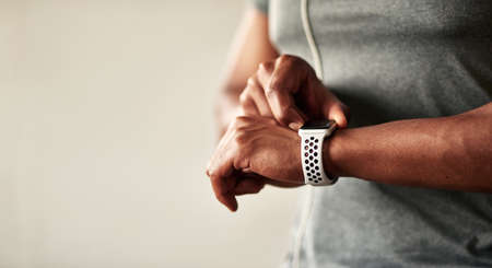 My fitness tracker motivates me to be more active. an unrecognizable man checking his wristwatch.の写真素材