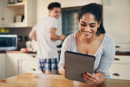 My morning feed is always entertaining. a young woman using a digital tablet while her boyfriend...