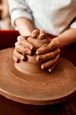 This is my creative outlet. an unrecognizable woman molding clay on a pottery wheel.の写真素材