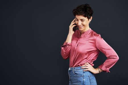 Hello How may I help. an attractive young businesswoman standing and talking on her cellphone...