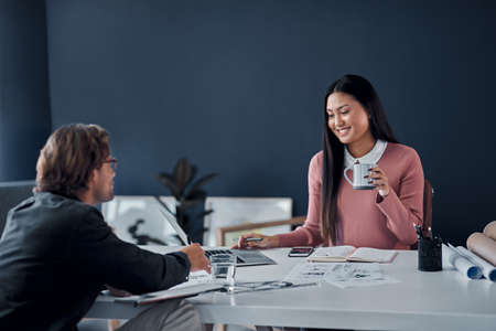 Shes loving the new designs. two young architects going over designs on a laptop together in their...
