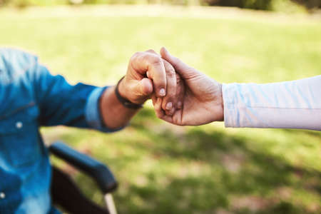 Ill hold your hand through it all. an unrecognizable woman holding a senior mans hands.の写真素材