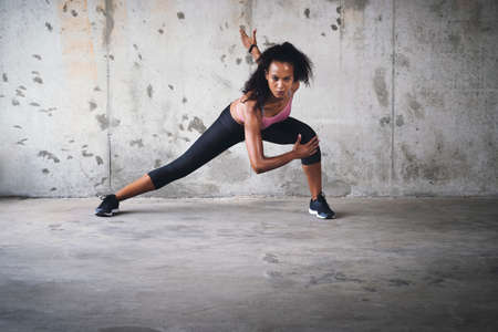 Always stay focused. Full length shot of an attractive young sportswoman stretching while exercising...