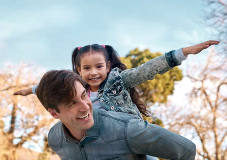 Are you ready for takeoff. an adorable little girl enjoying a piggyback ride with her father at the park.の写真素材