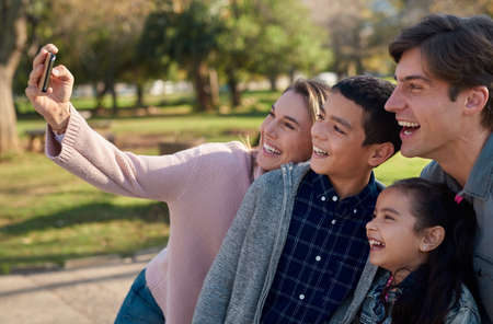 Family memories are the most treasured. a happy young family taking a selfie together in the park.の写真素材