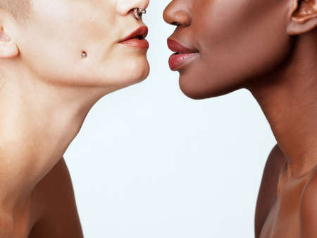 Beautiful is not a colour. Studio shot of two beautiful young women against a grey background.の写真素材