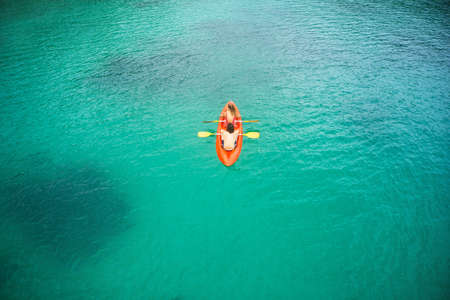 High angle shot of an adventurous young couple canoeing together in the beautiful oceans of Indonesia.の写真素材