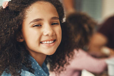 Portrait of an adorable little girl enjoying herself during a family gathering.の写真素材