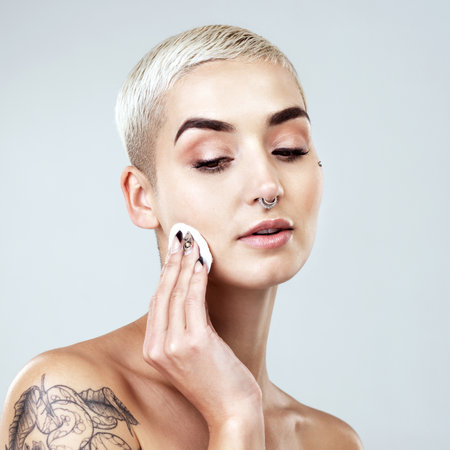 Studio shot of a beautiful young woman posing against a grey background.の写真素材