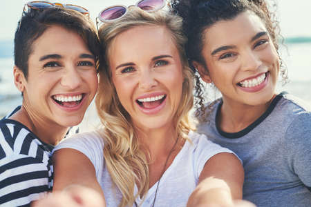 three friends spending the day together on a sunny day.の写真素材