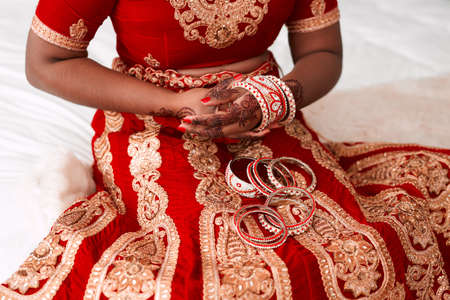 Putting on gracefulness. an unrecognizable bride putting on her bracelets in preparation for her...