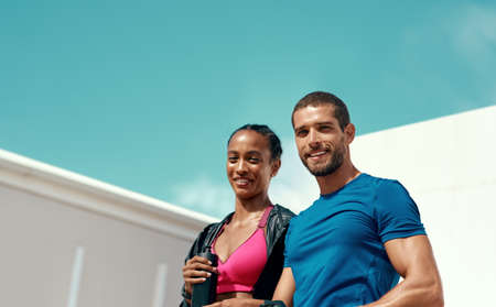 Youre one workout away from a good mood. two sporty young people standing together.の写真素材