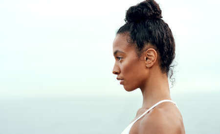 Keep your goals in sight. a sporty young woman exercising outdoors.の写真素材