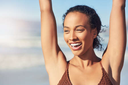 Im ready for a summery time. a beautiful young woman spending the day at the beach.の写真素材