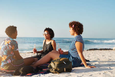 Nothing beats a sunny day with friends on the beach. Rearview shot of an attractive young trio of...