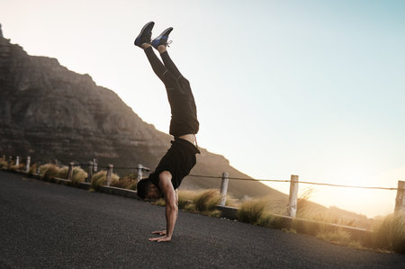 Youll become stronger and more flexible than before. a sporty young man doing a handstand while exercising outdoors.の写真素材