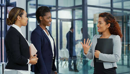 Successful women have a lot of things in common. three young businesswomen having a discussion at work.の写真素材
