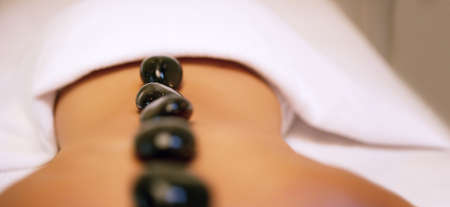 Stuck in the heat of the moment. an unrecognizable woman getting a hot stone massage at a beauty...