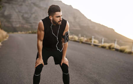Go all out and change your body. a sporty young man taking a break while exercising outdoors.の写真素材