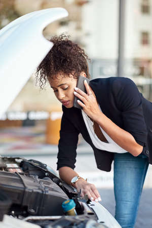This is not something she can fix alone. an attractive young businesswoman calling roadside...