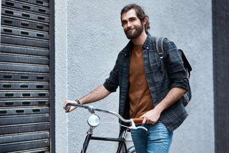 Im always down for a trip. a handsome young man travelling with his bicycle outdoors.の写真素材