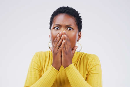 Is that true. Studio shot of a young woman looking shocked against a grey background.