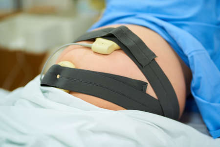 Modern technology has helped easily monitor the whole birthing process. an unrecognizable pregnant woman lying in her hospital bed on her due date.の写真素材
