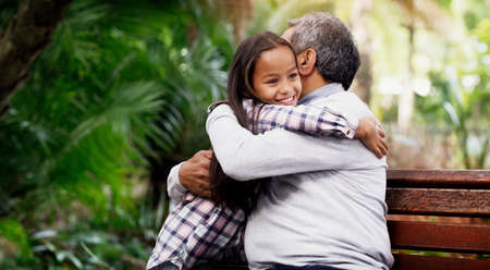 Granddaddys little princess. an adorable little girl hugging her grandfather in the park.の写真素材