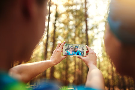 Selfies are a must. two sporty young woman taking pictures while out in nature.の写真素材