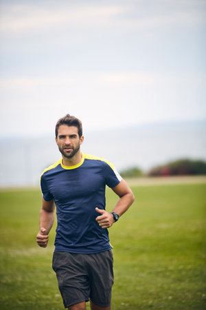 Exercise is what keeps me healthy. a sporty middle-aged man out running in a park.