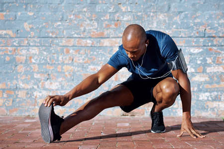The louder the music, the harder you workout. a sporty young man exercising outside.