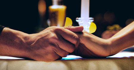 Hand in hand together, forever. an unrecognizable affectionate couple holding hands while sitting at...