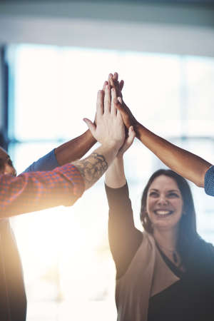 High five of business woman with office team celebrating team work, success and development support. Group of happy colleague hands together to celebrate. Employee celebration of a successful jobの写真素材