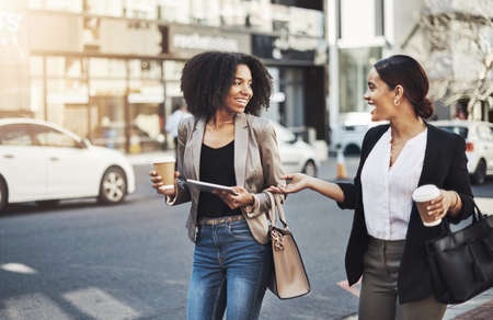 Making moves all around town. two businesswomen having a discussion while walking in the city.の写真素材