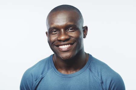 Im doing quite well actually. Studio shot of a handsome young man posing against a grey background.