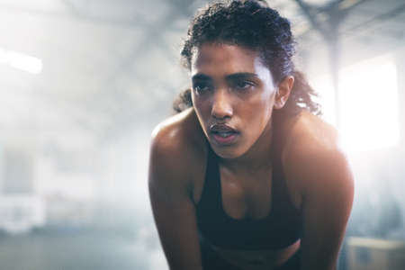 Wont give up, cant give up. a focused young sportswoman gathering her thoughts in the gym.の写真素材