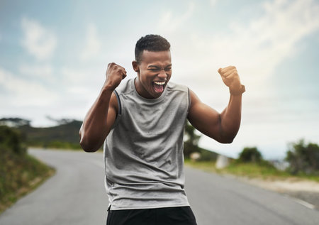 Im the champion. a handsome young sportsman cheering in celebration outside.の写真素材